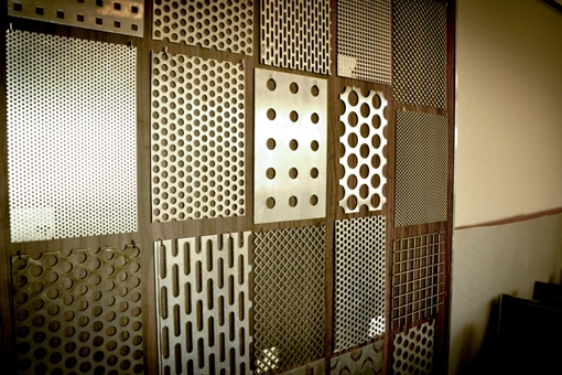 Ściana ekspozycyjna z różnymi wzorami blach perforowanych