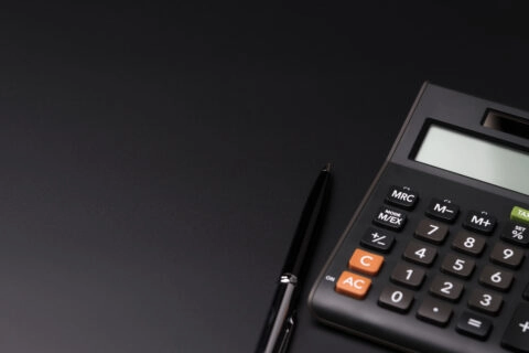 Czarny kalkulator i metalowy długopis