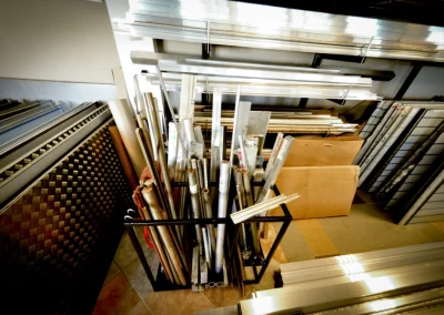 Metalowy stojak wypełniony różnymi profilami aluminiowymi